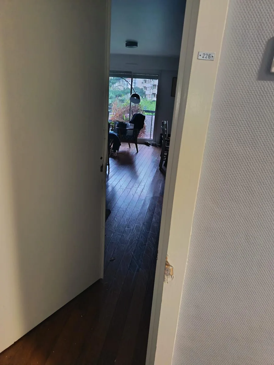 Porte d'appartement ouverte avec chambranle simplement marqué après ouverture fine