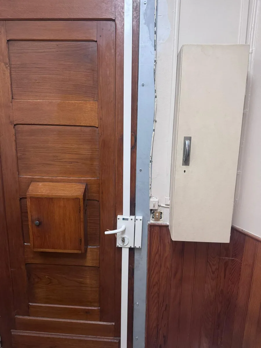 Serrure multipoints blanche à tringle sur porte en chêne